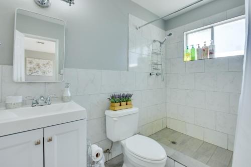 a white bathroom with a toilet and a sink at Las Vegas Retreat with Yard Less Than 5 Mi to Strip! in Las Vegas