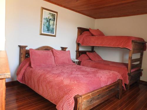 1 dormitorio con 2 literas con sábanas rojas en SORACA MANTO REAL, en Soracá