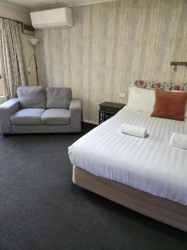 a hotel room with a bed and a couch at Amber Court Motel Nelson in Nelson