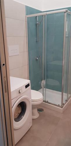 a bathroom with a washing machine and a toilet at GIOIA Holiday Home in Torre del Greco