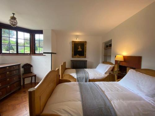 a hotel room with two beds and a dresser at Weston at Lulworth Cove in Lulworth Cove