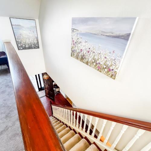 a staircase in a house with a painting on the wall at DOONEEN HOUSE in Killarney