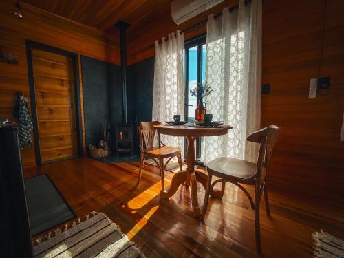 a table and chairs in a room with a window at É diferente, descubra por quê in Urubici