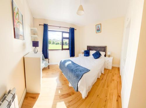 a bedroom with a bed and a large window at DOONEEN HOUSE in Killarney