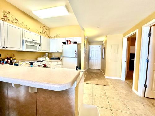 a kitchen with white cabinets and a white refrigerator at Windemere Unit 605 in Pensacola