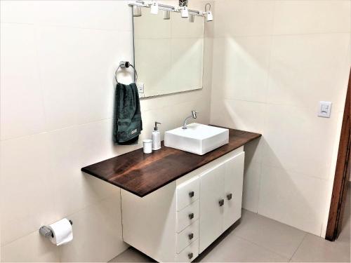 y baño con lavabo y espejo. en Sítio São Luiz, R2: Refúgio rústico na Natureza en Quadra