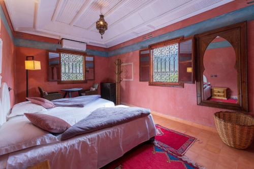 - 2 lits dans une chambre dotée de murs rouges et de fenêtres dans l'établissement Riad Tourtit, à Imlil