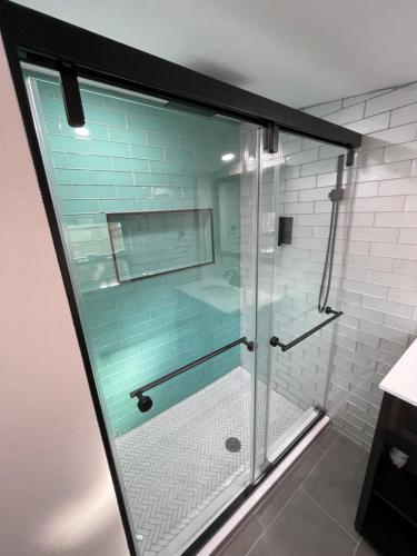 W łazience znajduje się prysznic ze szklanymi drzwiami. w obiekcie Cabana Tropical - Garden Studio with Private Hot Tub w St Pete Beach