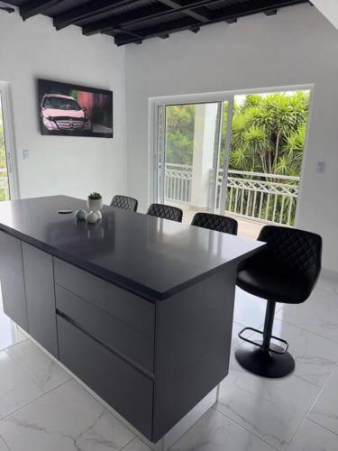 a large black island in a room with chairs at Casa Bella Vista Hermosa casa entre las Montanas piso 2 in Birrí