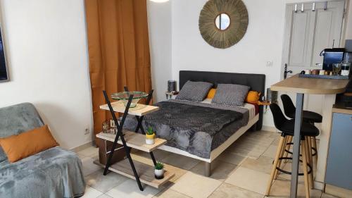 une chambre avec un lit, une table et une chaise dans l'établissement Le Ptit'Isle, à LʼIsle-sur-la-Sorgue