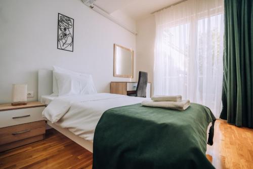 a bedroom with a bed with a green blanket on it at Darki Apartments 2 - Very Central Stay With Free Parking in Ohrid