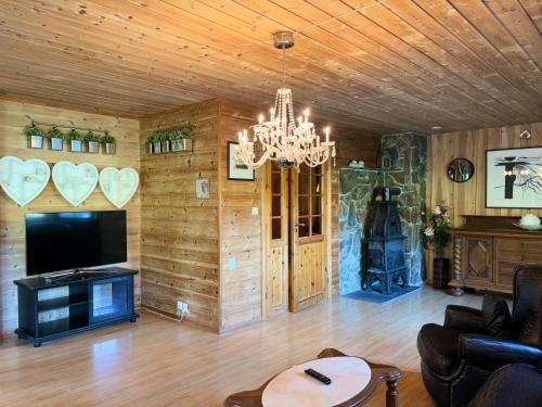 een woonkamer met een kroonluchter en een open haard bij Flåm holiday home - mountain view - 1 km from Flåm in Flåm