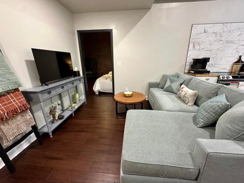 a living room with a couch and a tv at The Mercantile on the Katy Trail in Hermann