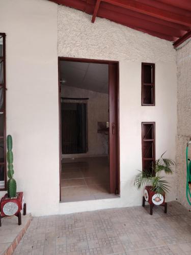 an open door of a white building with a potted plant at Casa con piscina, 1 cuarto barato in ArraijÃ¡n
