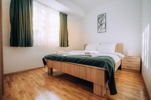 a bedroom with a bed and a window with green curtains at Darki Apartments 2 - Very Central Stay With Free Parking in Ohrid