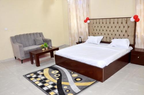 1 dormitorio con 1 cama, 1 silla y 1 alfombra en Sunflower Guest inn, en Kano