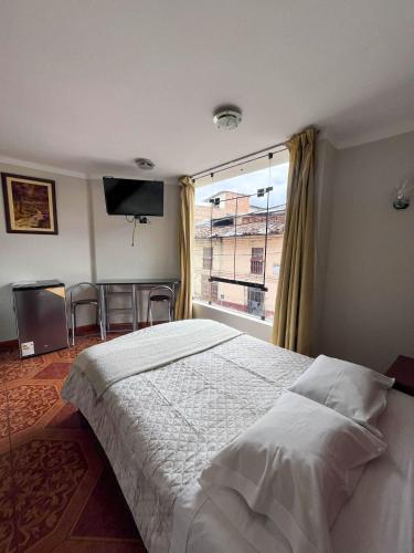 ein Schlafzimmer mit einem großen Bett und einem großen Fenster in der Unterkunft Retamas Hotel EIRL in Cajamarca