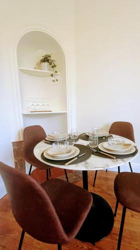- une table à manger avec des chaises et des assiettes dans l'établissement Cosy 2 bedrooms apartment close to Nancy thermal, à Nancy