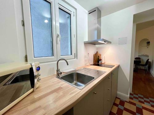une cuisine avec un évier et une fenêtre dans l'établissement Cosy 2 bedrooms apartment close to Nancy thermal, à Nancy