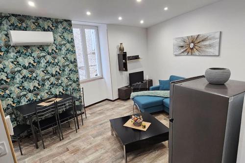 un salon avec un canapé bleu et une table dans l'établissement Appartement Kantar - Le Vert D'Agate, à Anduze