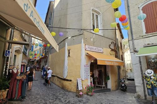 Un groupe de personnes marchant dans une rue étroite dans l'établissement Appartement Kantar - Le Vert D'Agate, à Anduze