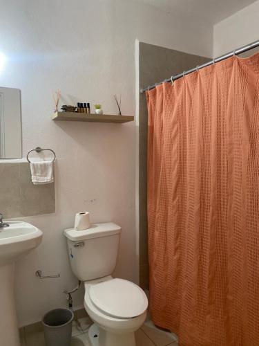 y baño con aseo y cortina de ducha. en Departamento Los Héroes Veracruz, en Veracruz