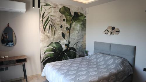 a bedroom with a blue bed with a painting on the wall at Villa Onari in Alexandroupoli