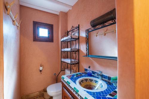 a bathroom with a sink and a toilet and a mirror at Riad Tourtit in Imlil