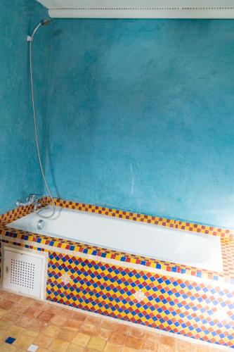 a bath tub in a bathroom with a blue wall at Riad Tourtit in Imlil