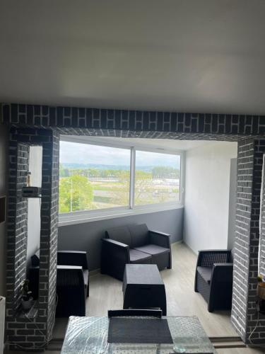 un soggiorno con divano e una grande finestra di Appartement 2 pièces à Cabourg a Cabourg