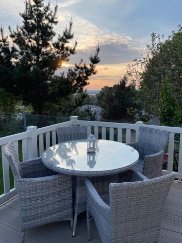 a table and chairs on a deck with a table and a tree at Rockley Valley TV36 in Lytchett Minster