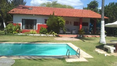 une maison avec une piscine en face de celle-ci dans l'établissement Casa de praia Vera, à Caucaia