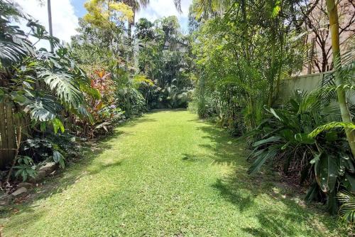un sentiero in un giardino con erba verde e alberi di 3br house, 5 min walk to beach with parking a Sydney