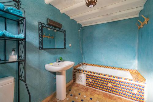 a blue bathroom with a sink and a tub and a sink at Riad Tourtit in Imlil