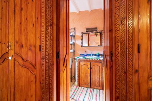 a bathroom with a sink and a wooden door at Riad Tourtit in Imlil