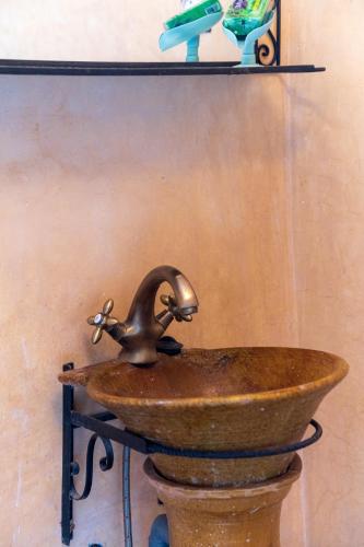 a rusty sink with a faucet on a wall at Riad Tourtit in Imlil