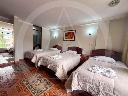 a hotel room with three beds in a room at Retamas Hotel EIRL in Cajamarca