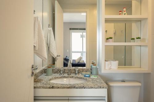 ein Badezimmer mit Waschbecken und Toilette in der Unterkunft Studio com garagem, ar condicionado e piscina in São Paulo