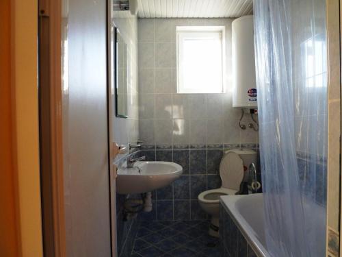 a bathroom with a sink and a toilet and a window at Sunny Villa in Dobrich