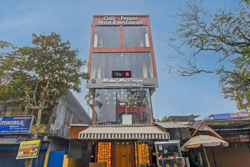 OYO Chilli Pepper Hotel and Restaurant في kolkata: مبنى طويل مع علامة على قمة مبنى