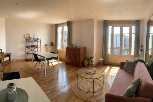 un salon avec un canapé et une table dans l'établissement Beautiful apartment with views & perfect for Olympic Games, à Asnières-sur-Seine