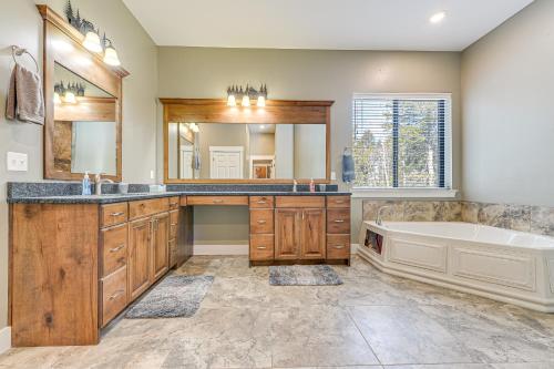 a bathroom with a tub and a sink and a mirror at Star Valley Ranch Vacation Rental with Resort Perks! in Thayne