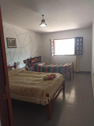 1 dormitorio con 2 camas y ventana en Uziel en Humahuaca