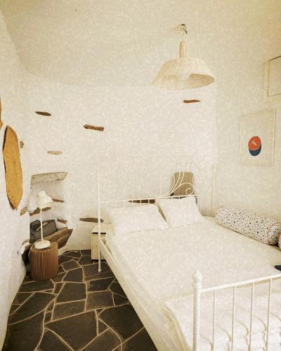 - une chambre avec un lit blanc dans l'établissement Sifnos Twin Houses, à Apollonia