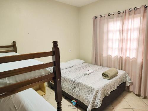 1 dormitorio con 2 literas y ventana en Pousada Catarina en Biguaçu