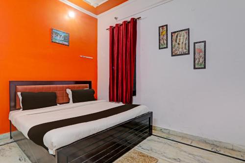 ラクナウにあるOYO Flagship Drip Stay Innのオレンジ色の壁のドミトリールームのベッド1台分です。