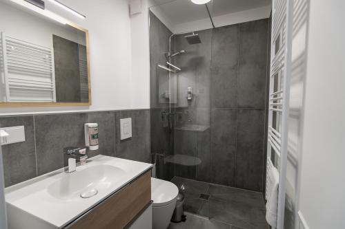a bathroom with a sink and a toilet and a shower at Helios Berlin Apartments in Berlin