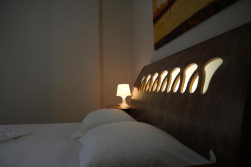 a bedroom with a bed with a light on it at Sol Central Apartament in Durrës