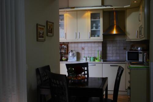 a kitchen with a table with chairs and a microwave at Sol Central Apartament in Durrës