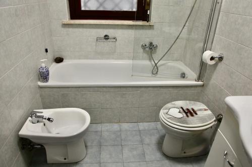 a bathroom with a tub and a toilet and a sink at 4four Apartment 6-7 pax in Vitinia